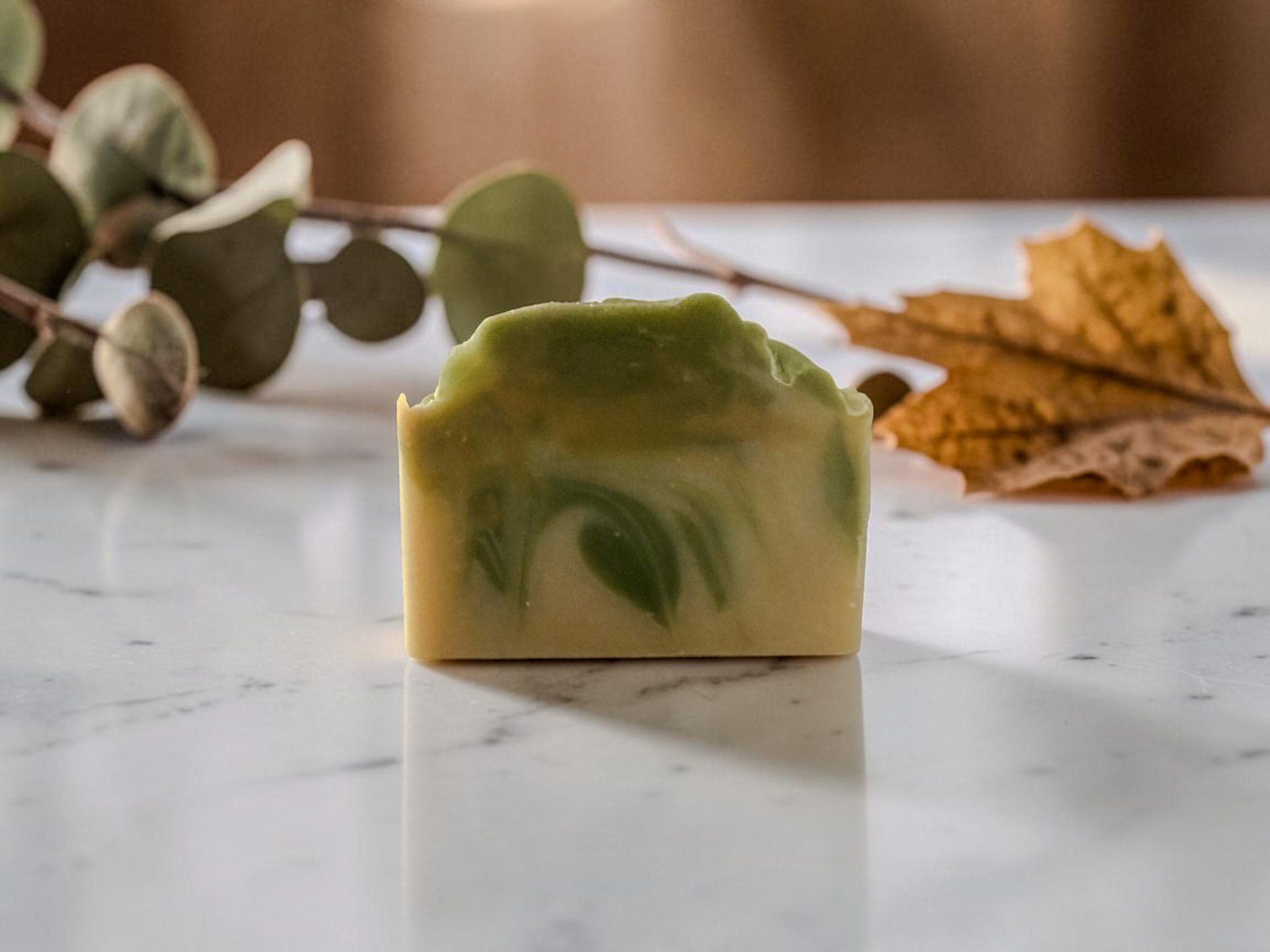 Velvet Pear Soap, a pale cream handmade bar on a marble counter